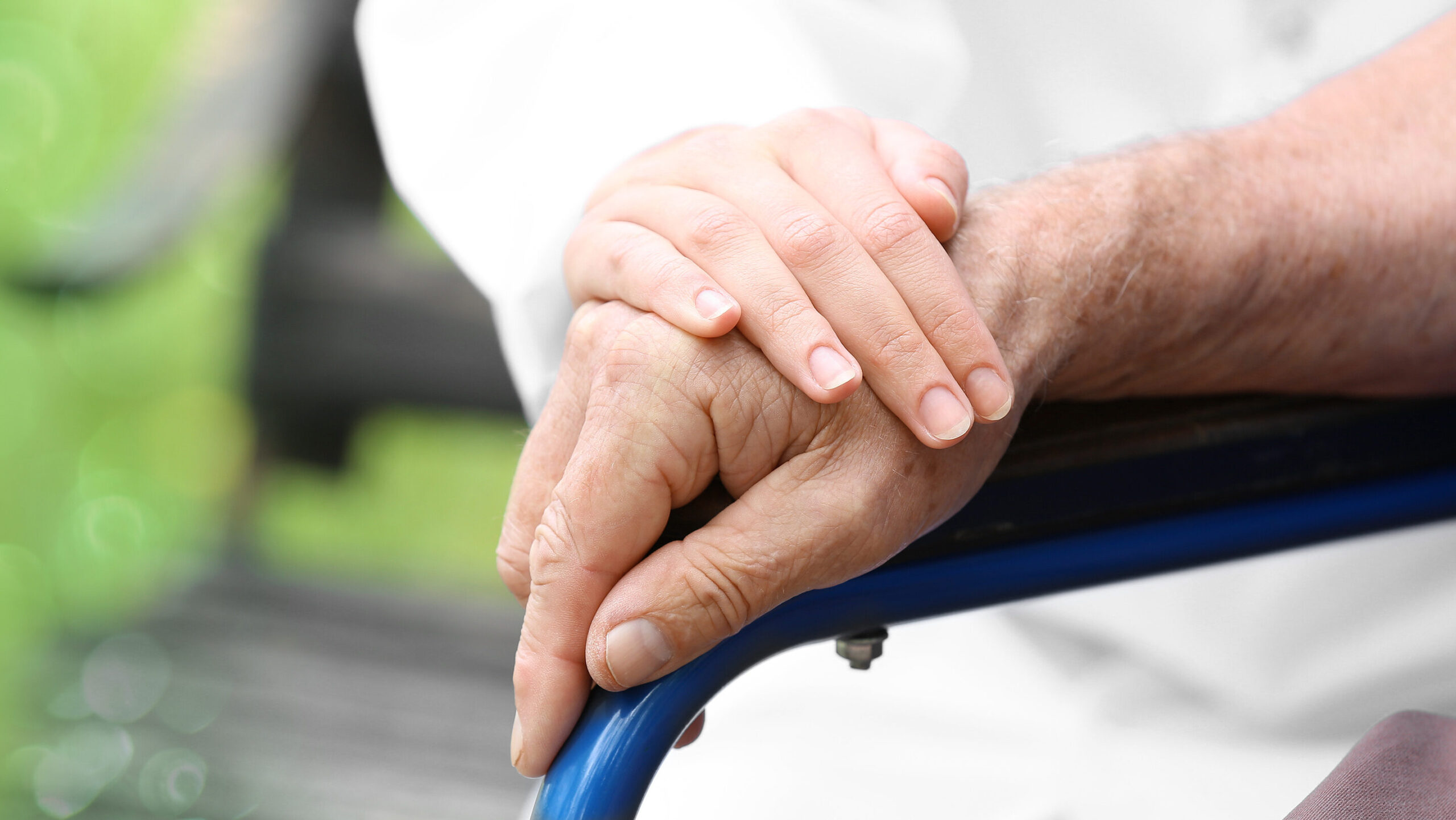 Elderly man with young caregiver in park, closeup Caregiver per ADI a L'Aquila